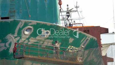 A ship worker repainting some green parts of the big ship GH4 4K