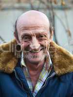 Portrait of a smiling elderly man outdoors closeup