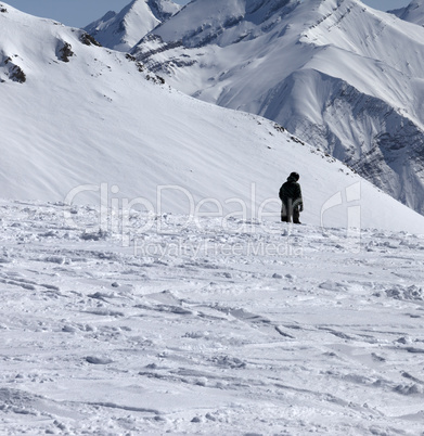Ski trail and snowboarder in sun winter day