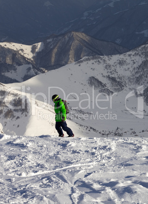 Snowboarder on off-piste slope in sun evening