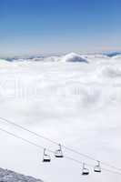 Mountains under clouds and chair-lift