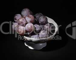 vase with grapes on a black background