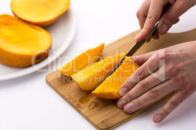 Mango Divided Into Thirds Being Subdivided Further