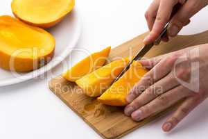 Mango Divided Into Thirds Being Subdivided Further