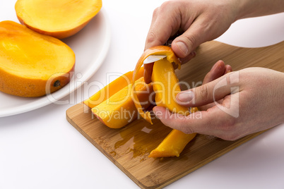 Hands Separating Mango Fruit Flesh From Its Skin