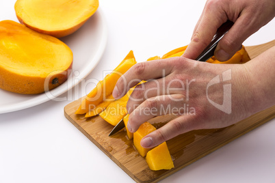 Mango Wedges Being Diced On A Wooden Cutting Board