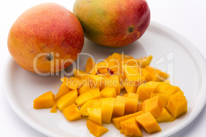 Juicy Mango Dice And Two Entire Mangos On A Plate