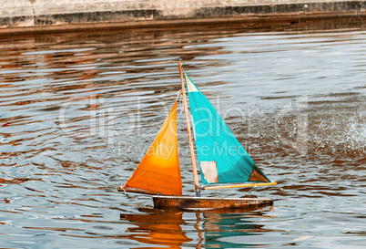 Small toy boat sailing on a lake