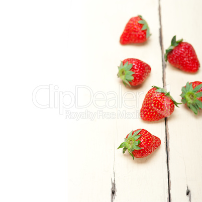 fresh organic strawberry over white wood