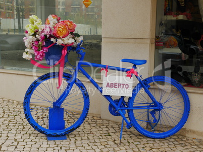 Blaues Fahrrad vor Geschaeft
