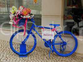 Blaues Fahrrad vor Geschaeft
