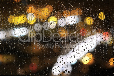 Fensterscheibe mit Regentropfen bei Nacht