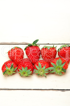 fresh organic strawberry over white wood
