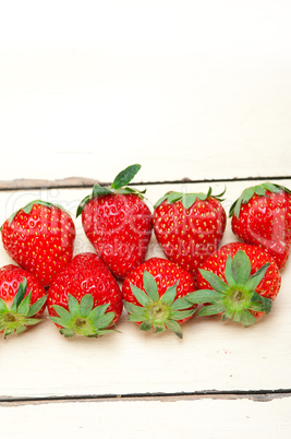 fresh organic strawberry over white wood