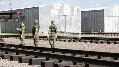 Soldiers build railway. Warehouse in background.