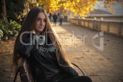 girl the bench autumn background with yellow leaves on