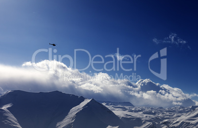 Helicopter above snowy plateau in evening