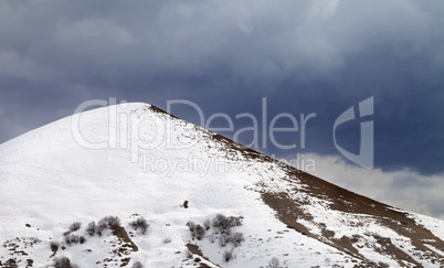 Off-piste slope and overcast gray sky