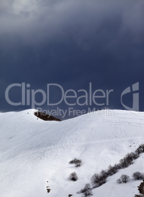 Off-piste slope and overcast gray sky in windy day