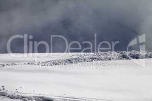 Sunlight off-piste slope and mountains in mist