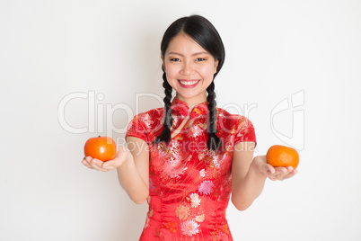 Asian chinese girl holding tangerine