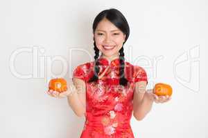 Asian chinese girl holding tangerine