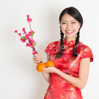 Asian chinese girl holding tangerine and plum blossom