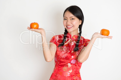 Asian chinese girl holding tangerine orange