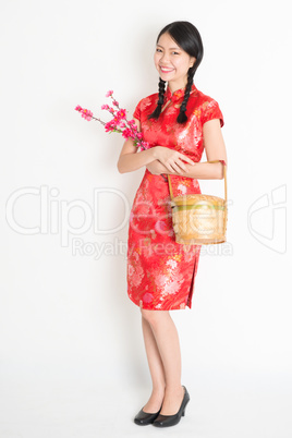 Chinese girl holding gift basket and plum blossom