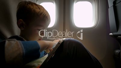 Little boy playing on touch pad in the plane