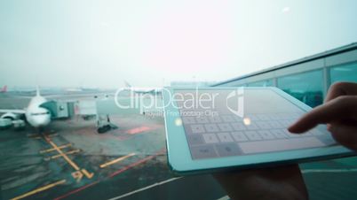 Using tablet computer by the window at airport