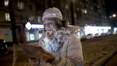 Happy woman watching something on pad during evening walk