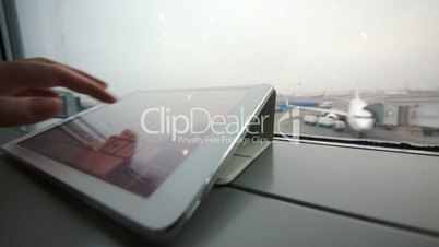 Using tablet PC on windowsill at the airport