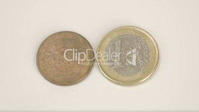A bronze plated Austia coin and 1 Euro coin
