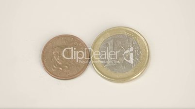 A small bronze France coin and 1 Euro coin