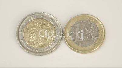 An indian man image on a Italian coin and a 1 Italy Euro coin