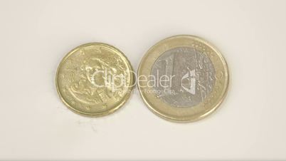 A small gold plated Italy coin and a 1 Euro coin