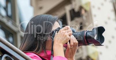 Female tourist on top of Eiffel Tower taking pictures of Paris