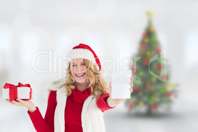 Composite image of festive blonde holding gift on right hand