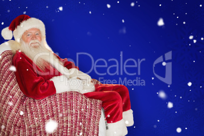 Composite image of smiling santa relaxing on the armchair