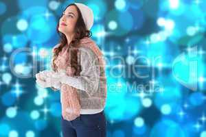 Composite image of brunette in winter clothes with hands out