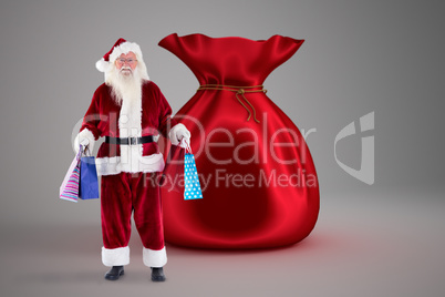 Composite image of santa carries some christmas bags
