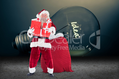 Composite image of santa holding pile of gifts