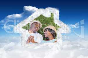 Composite image of happy couple lying in garden together on the