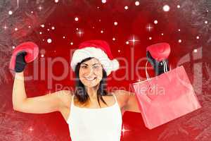 Composite image of festive brunette in boxing gloves holding sho