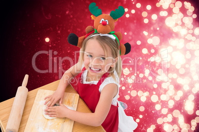 Composite image of festive little girl making cookies