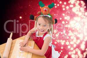 Composite image of festive little girl making cookies