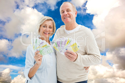 Composite image of happy mature couple smiling at camera showing