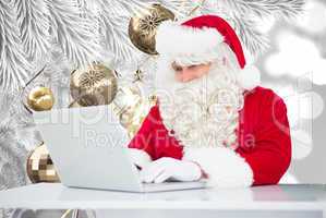 Composite image of santa using laptop