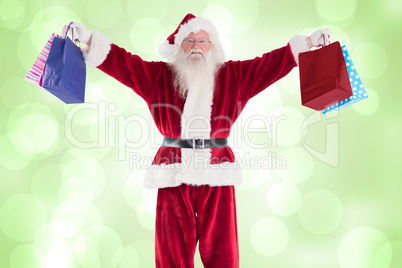 Composite image of santa holds some bags for chistmas